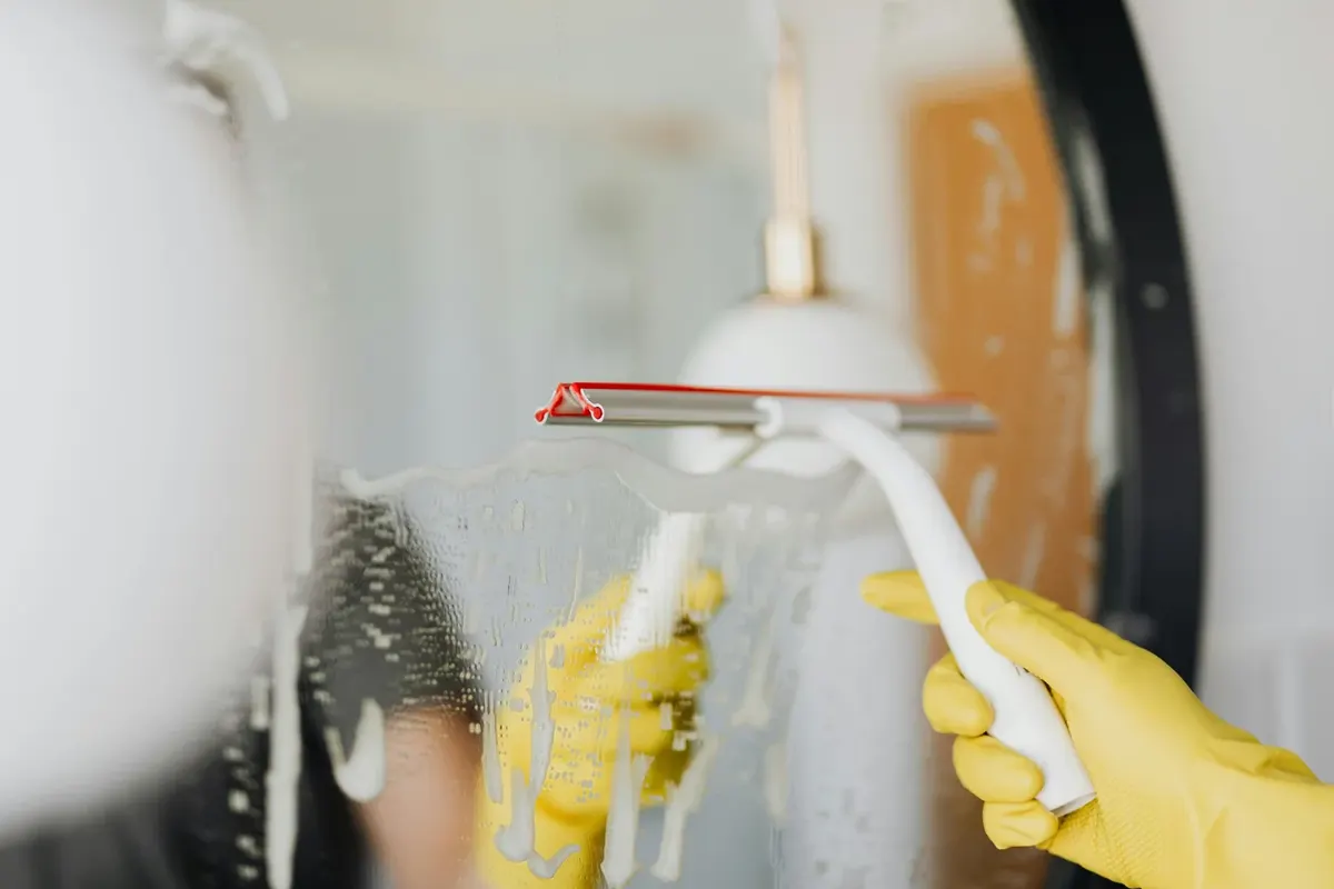 Squeegee clearing water from shower glass